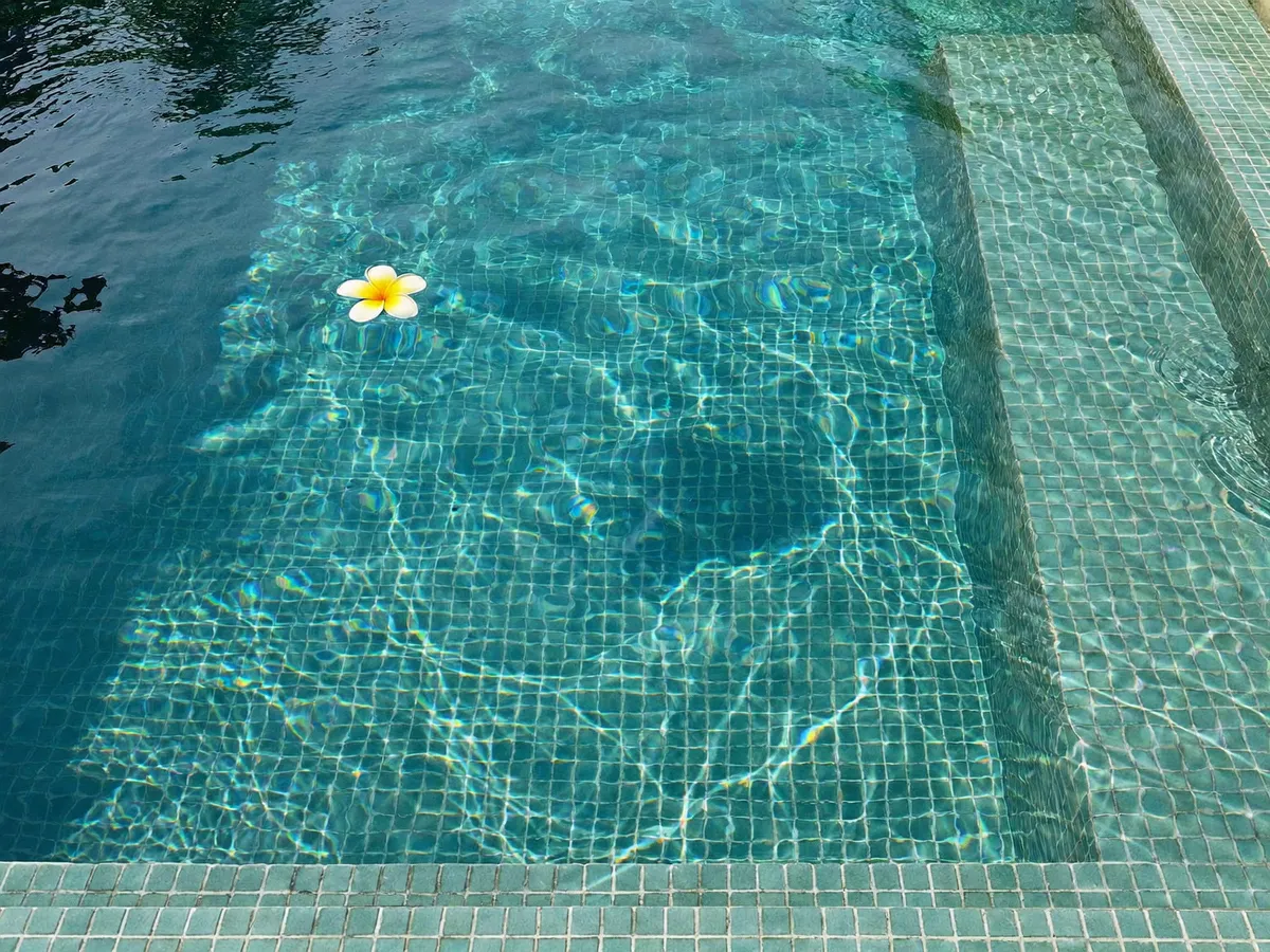Turquoise glass mosaic tiles lining a Bali villa swimming pool